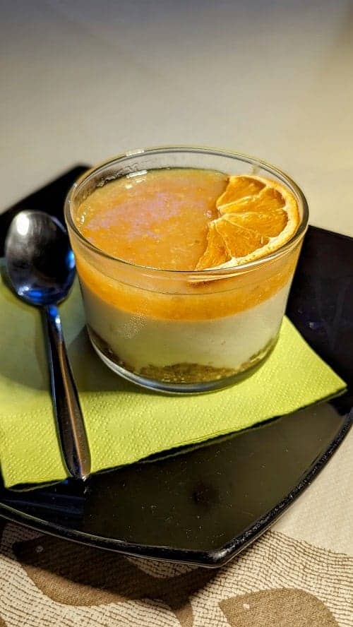 a vegan cheesecake topped with orange marmalade in a small glass jar at la tecia vegana in venice italy