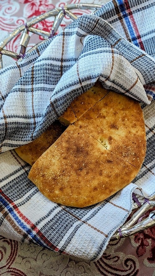 a fresh loaf of vegan bread covered in a black and white checkered towel in morocco