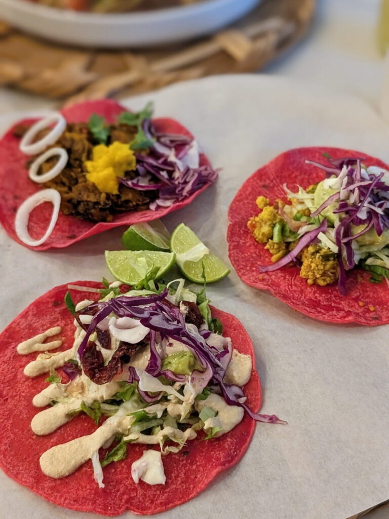 three vegan tacos on pink taco shells at la pitayah vegana