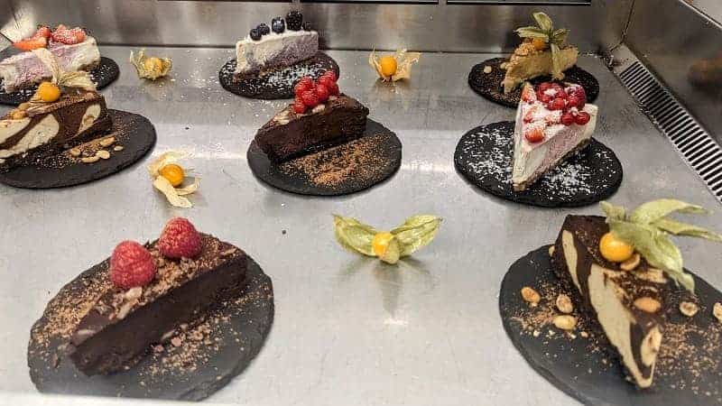a selection of raw vegan chocolate cake slices in a dessert display at raw firenze  in florence