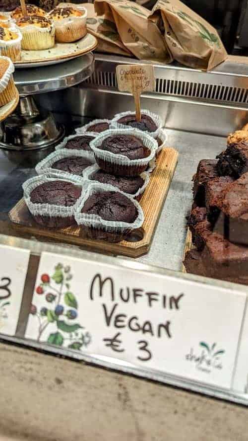 chocolate vegan muffins in a row inside of a bakery case at shake cafe in florence