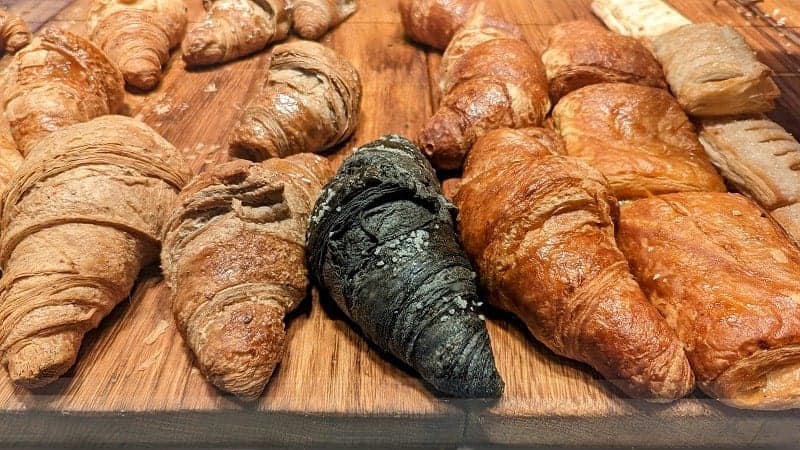 a display of golden vegan croissants on a wood board at Teraferma in venice