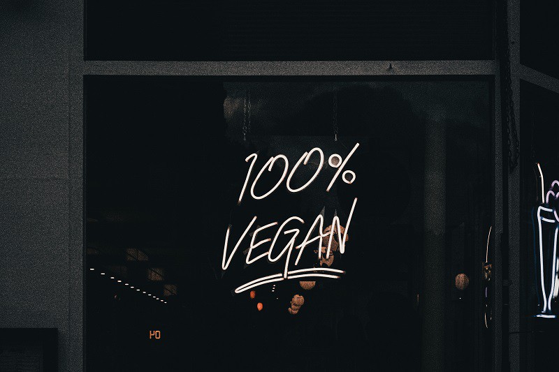 a neon sign on a dark all that says 100% vegan