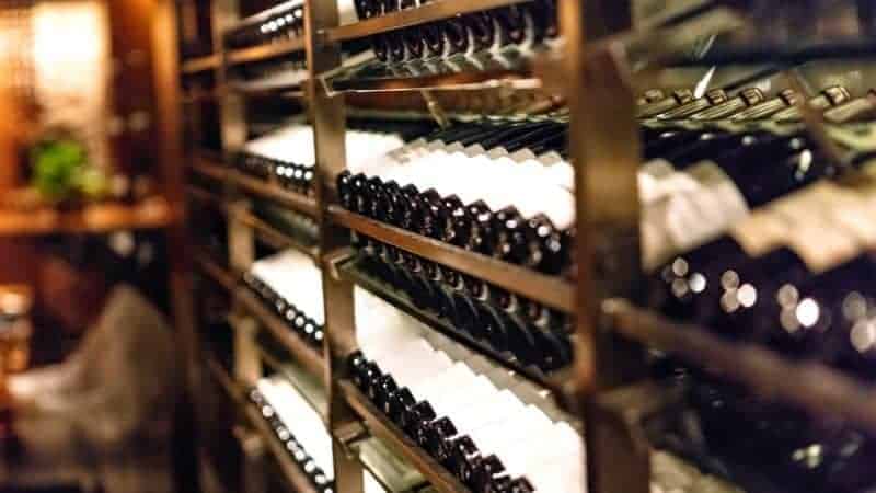 a wine cellar with a long row filled with multiple shelves filled with bottles of wine