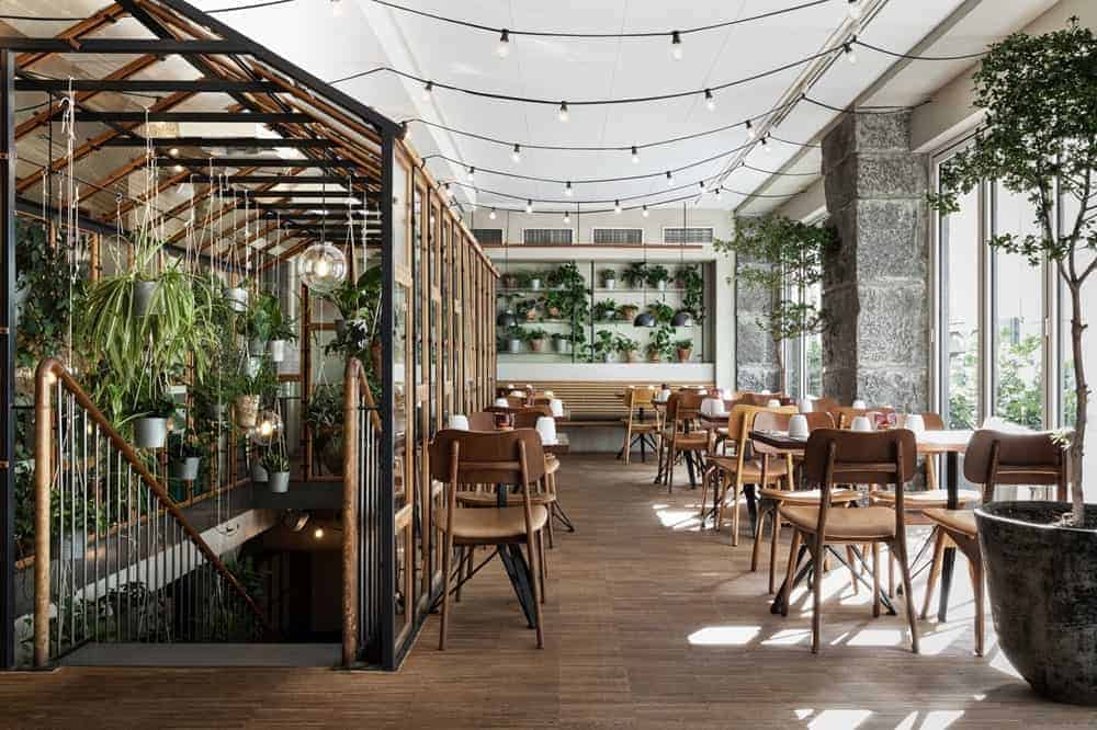 the bright and light filled breakfast room with wood tables and strands of lights at hotel sp34 in copenhagen