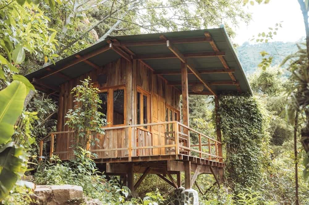 wooden treehouse perched above the lush jungle on a mountainside in Guatemala 