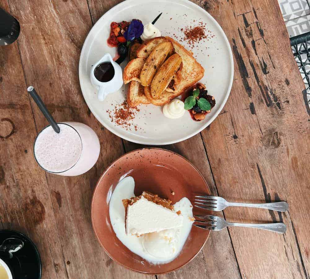 vegan toast covered with carmelized banana next to a slice of cake with partially melted ice cream at a cafe in bali