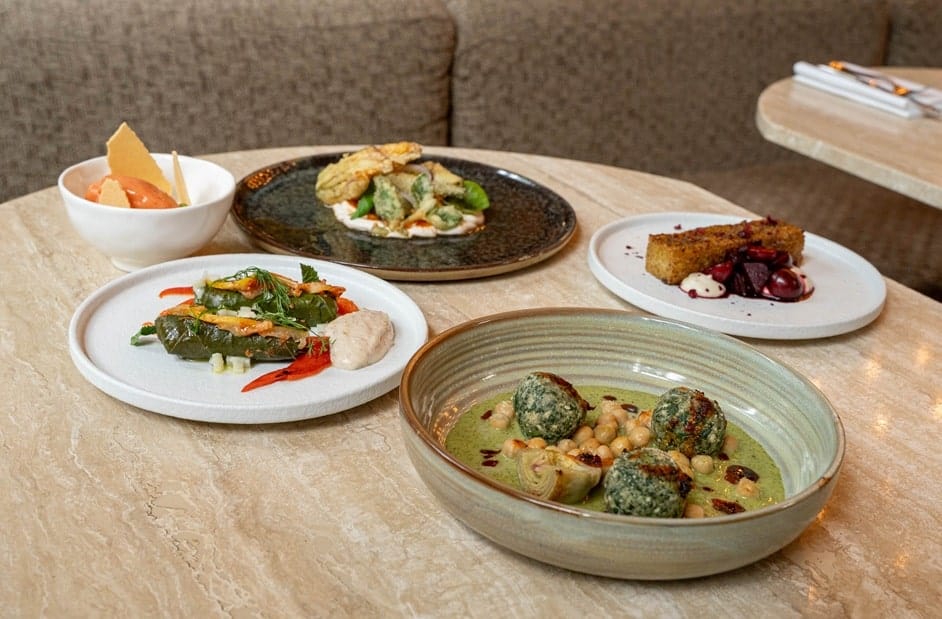 four course vegan dinner spread across a wood table at bonboon in amsterdam