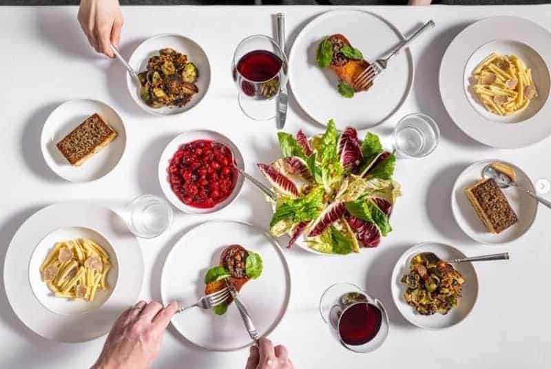 giant spread of tiny vegan dishes on a white clothed table at the michelin starred vegan restaurant eleven park madison in nyc