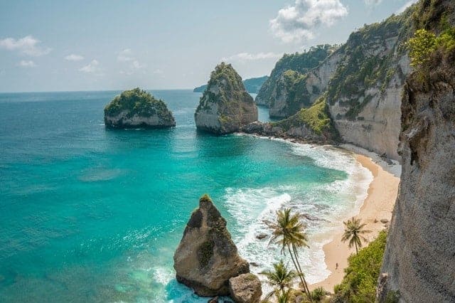secluded white sand beach surrounded by turquoise water in nusa penida bali