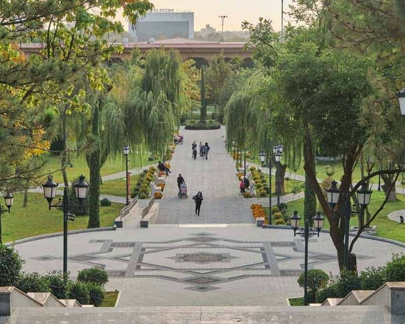 Amir Temur Square surrounded by green trees with people walking through in tashkent uzbekistan
