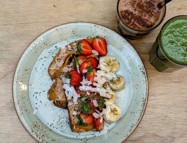 vegan and gluten free sweet potato toast covered in almond butter, banana and strawberry slices at shake cafe in florence