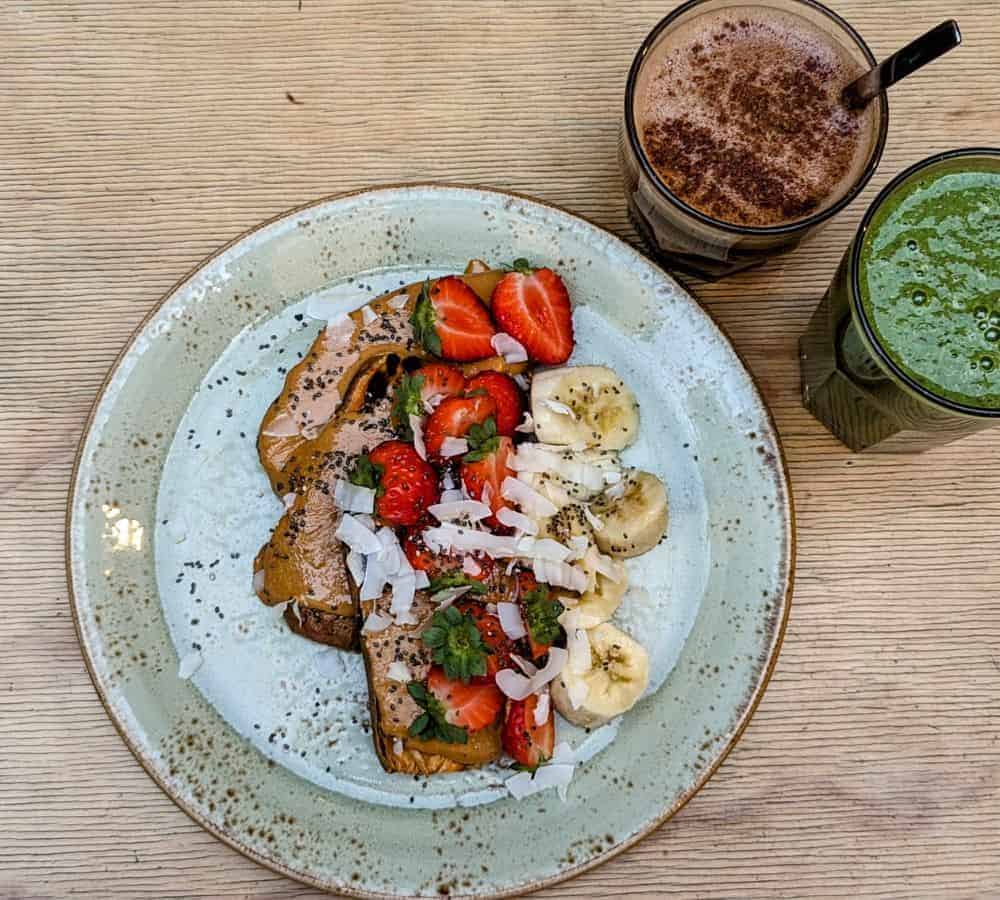 vegan and gluten free sweet potato toast covered in almond butter, banana and strawberry slices at shake cafe in florence