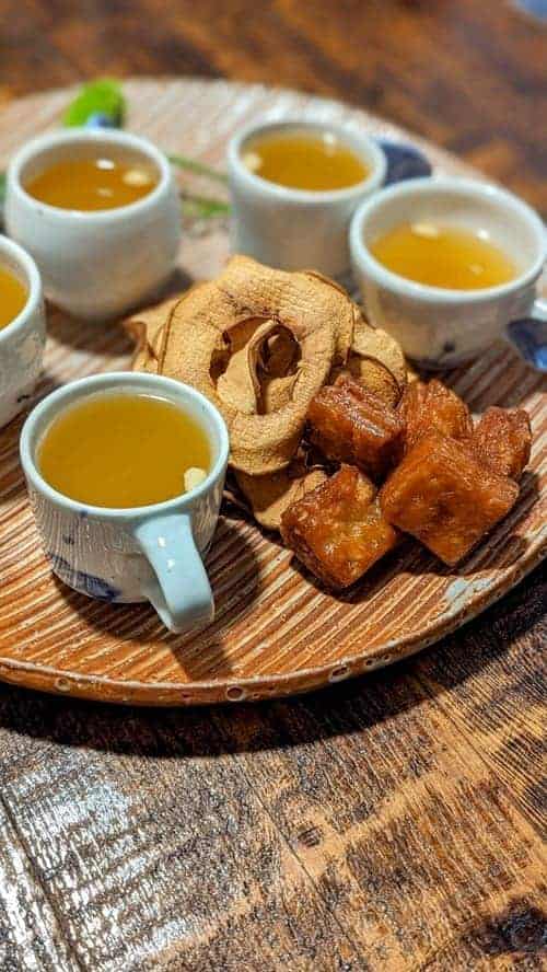 fried sugar dough cubes on a wood platter next to mugs of pumpkin juice at  a flower blossom on the rice in seoul