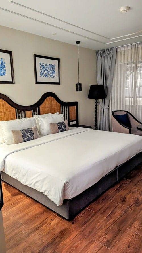 a queen sized bed in a neutral color room at the vegan hotel away chiang mai