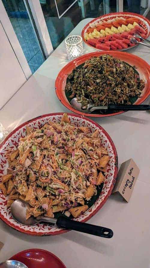 two large platters with vegan salads on a long white table at free bird cafe chiang mai