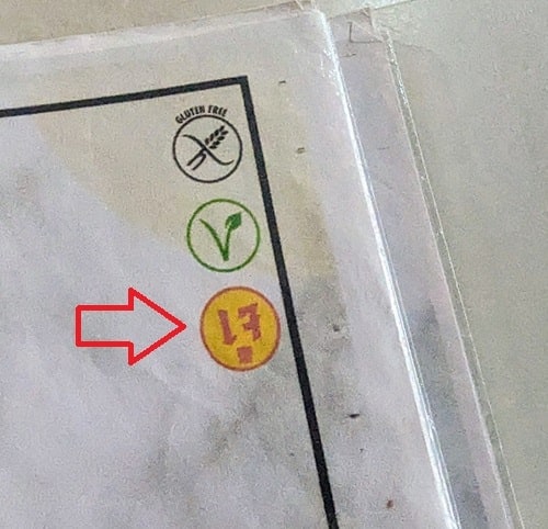 a white menu with a black wheat symbol for gluten free, a green sprouting v for vegan and a red and yellow image for jain