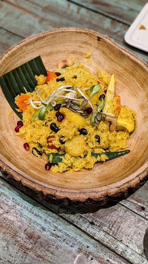 yellow pineapple fried rice in a beautiful wood bowl at the vegetarian restaurant mango in bangkok