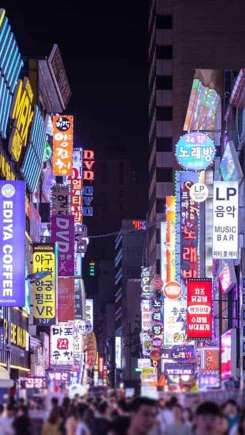 neon lights and signs lit up in a seoul neighborhood at night