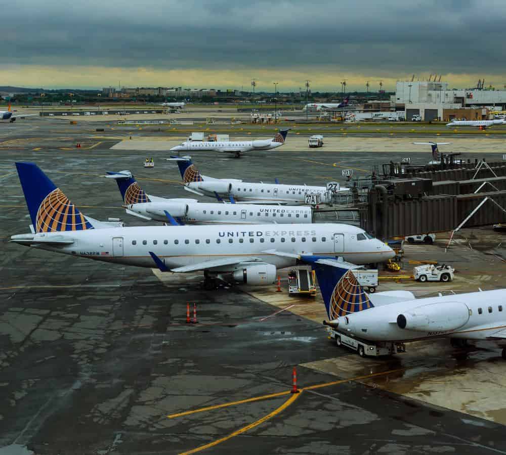 four united airline airplanes parked at an airport waiting for passengers to board