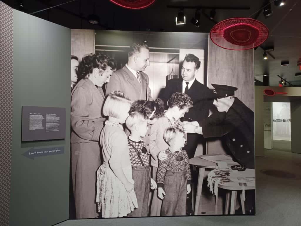 a black and white photo of a family immigrating to canada that's on display at the Canadian Immigration Story Exhibit in halifax