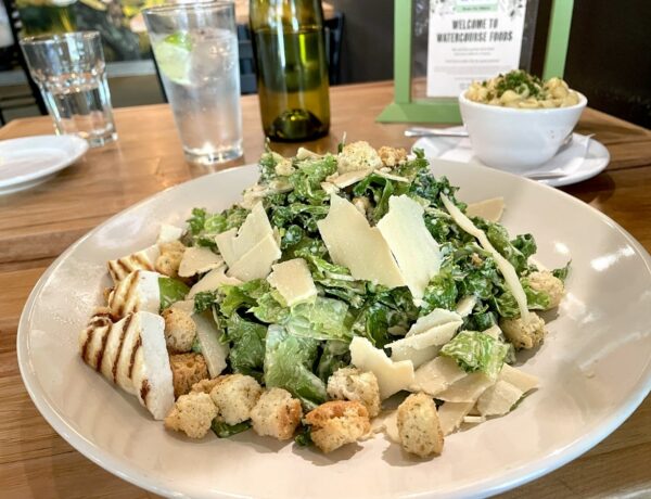 vegan Cesar salad with grilled tofu and garlic croutons on a white plate at watercourse foods in denver