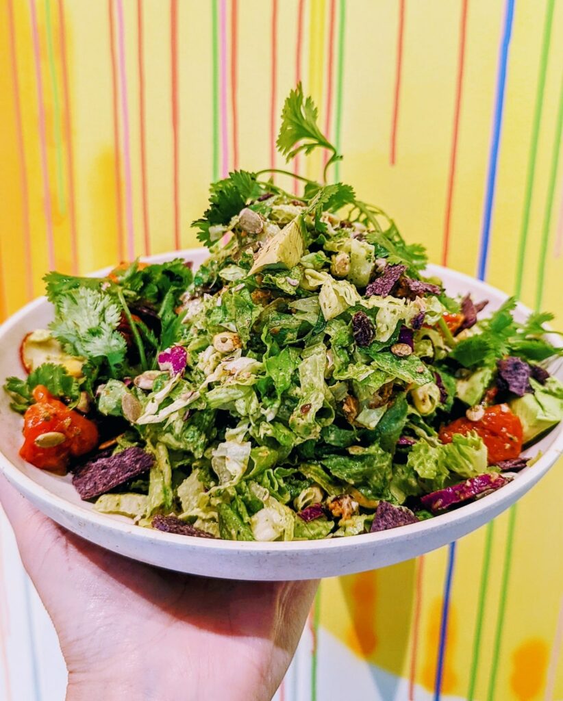 vegan chopped salad in front of a colorful wallpaper background