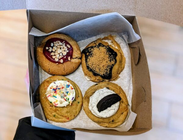 a box with four vegan cookies topped with marshmallow fluff, sprinkles, chocolate and jam at the vegan bakery, bonus bakery in vancouver, bc