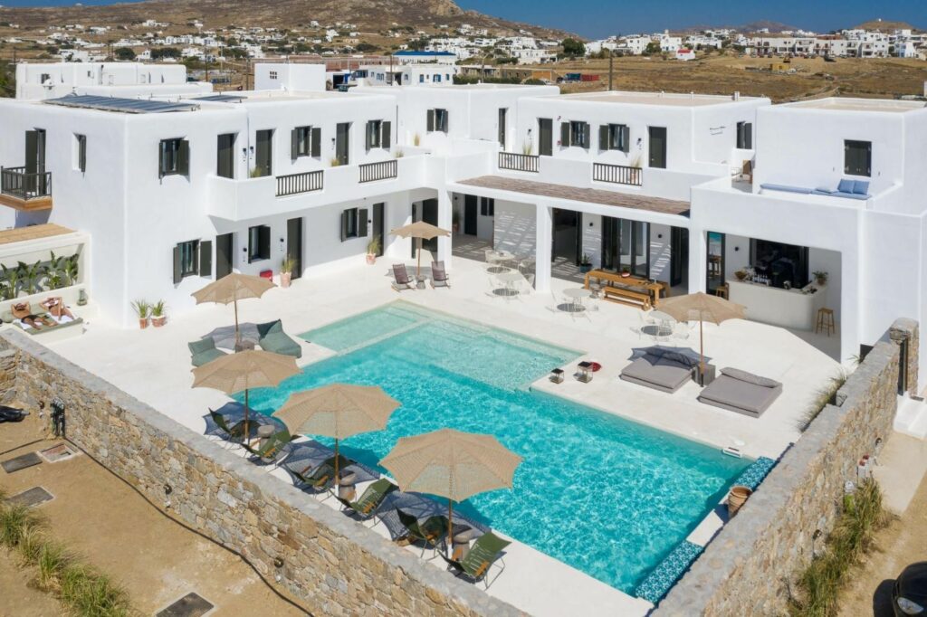 overhead shot of the outdoor pool in the back of the white stone vegan hotel Koukoumi on a bright sunny day in mykonos