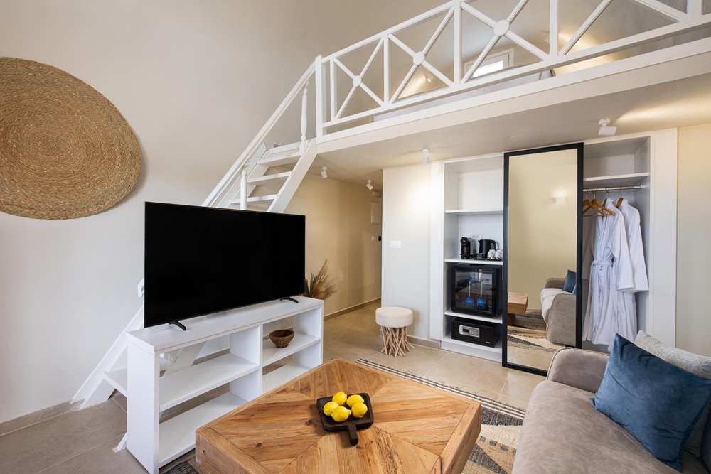 a modern and sleek guest room with white walls and furniture at the vegan hotel noverian bios in santorini