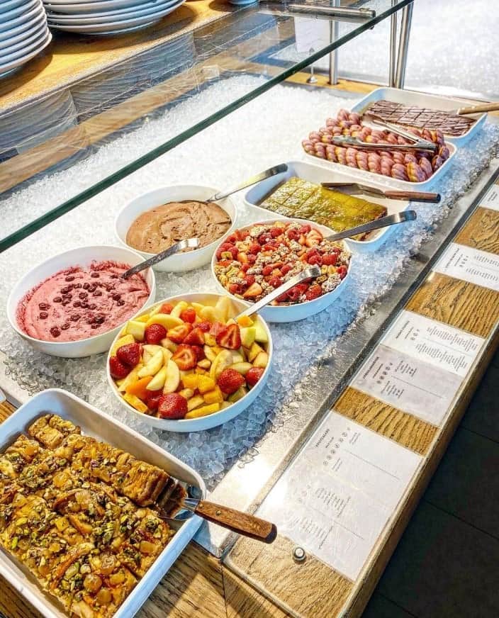 a small buffet filled with vegan breakfast items like fresh fruit, coconut yogurt, pancakes, and more at spirit amsterdam