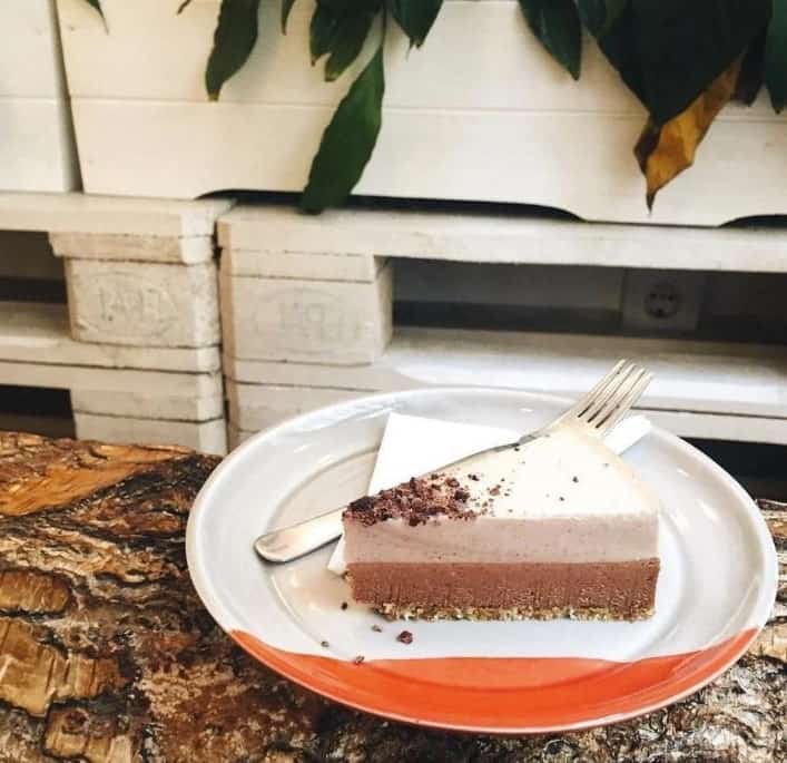 a single slice of chocolate mousse cake on a white plate with a fork in budapest