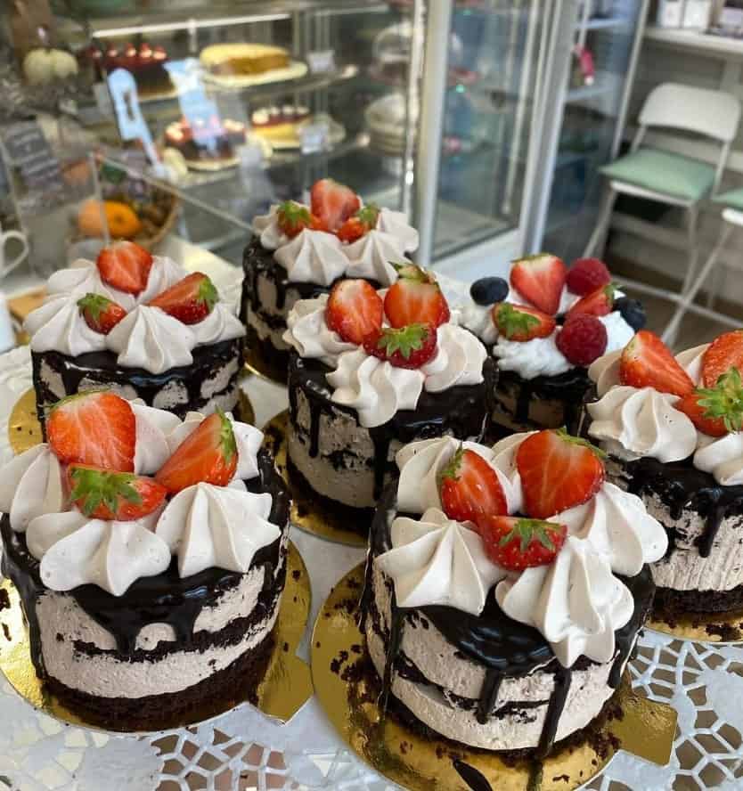 eight individual vegan chocolate cream cakes topped with sliced strawberries in vienna