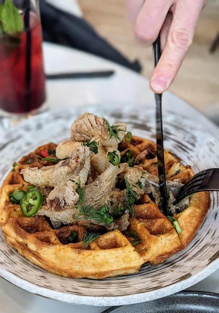 a vegan waffle topped with crispy mushrooms and maple syrup at planta in toronto