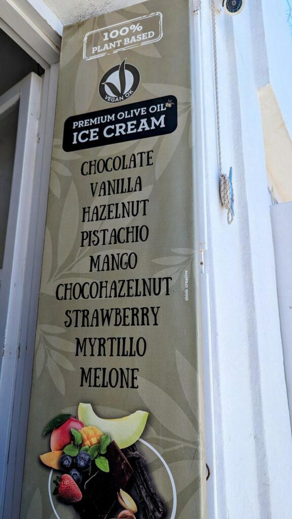 a long green sign with vegan ice cream flavors at Assyrtico in santorini