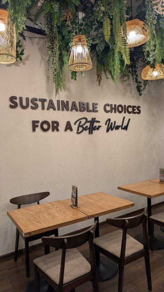 inside the vegan restaurant kem kon in bangkok with writing on the wall that says "sustainble choices for a better world"