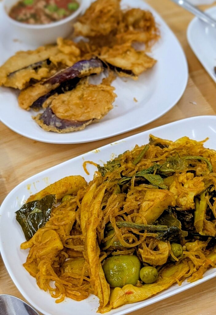 two vegan dishes one with glass noodles and the other is fried eggplant at ming kwan in chiang mai