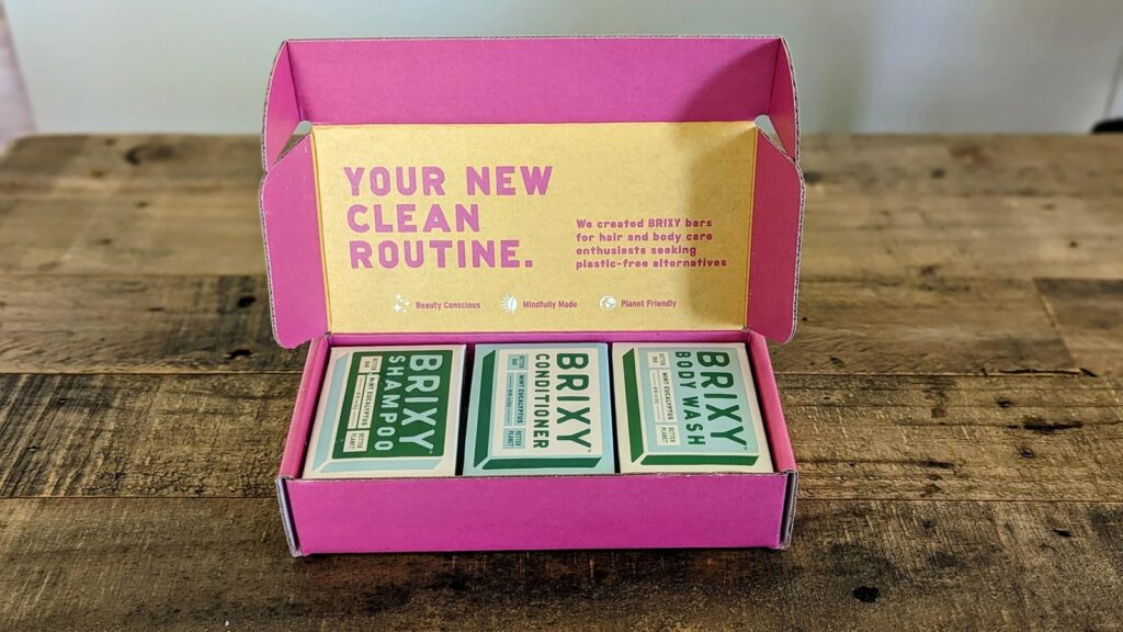 a box of three brixy bar products for shampoo, conditioner and bodywash on a wood table