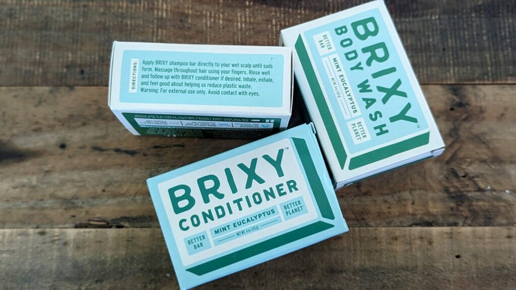 a mint and eucalyptus shampoo, conditioner and body wash bar on a wood table 