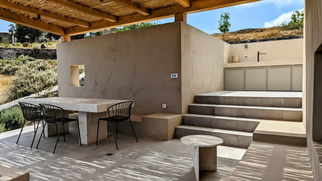 large outdoor dining space with a communal dining table and cooking space at ethos vegan retreat in santorini