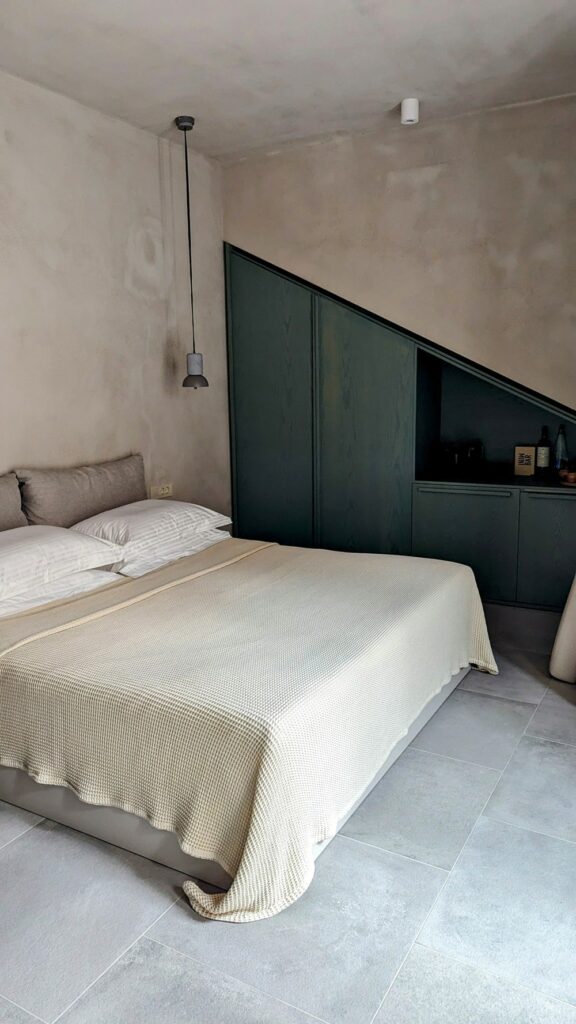 king bed in a modern guestroom with blue cabinets at ethos vegan retreat in santorini