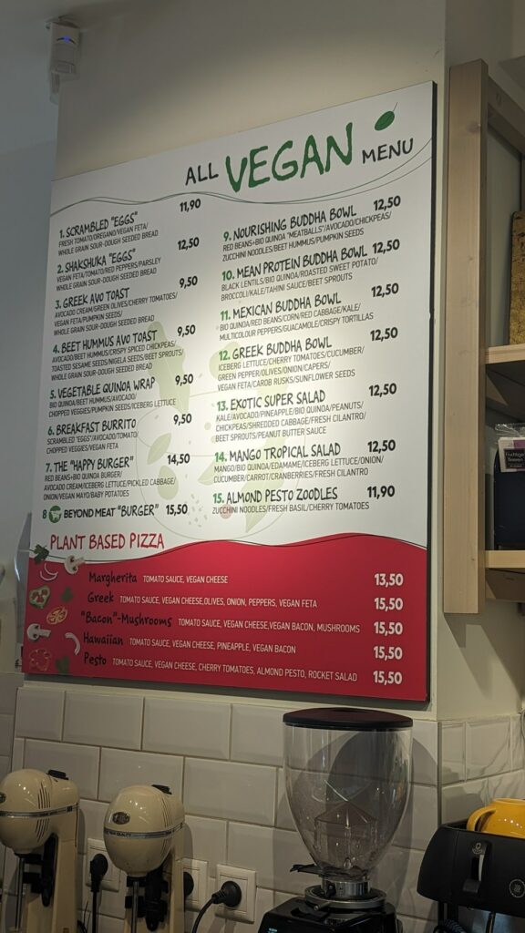 the large vegan menu hanging on the wall at happy blender in athens, greece