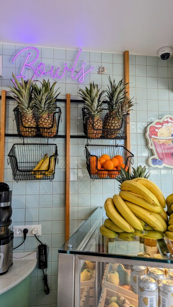 inside of the colorful stolen fruit cafe with fresh pineapple and bananas on display in santorini
