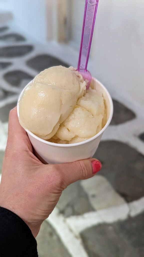 a small white bowl with a scoop of vegan passionfruit ice cream and a scoop of lemon sorbet in mykonos