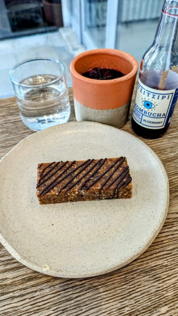 a small vegan peanut butter bar with a drizzle of chocolate on a white plate in athens greece
