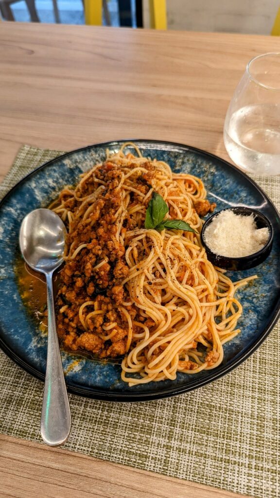 a large blue bowl filled with vegan spaghetti Bolognese in santorini 