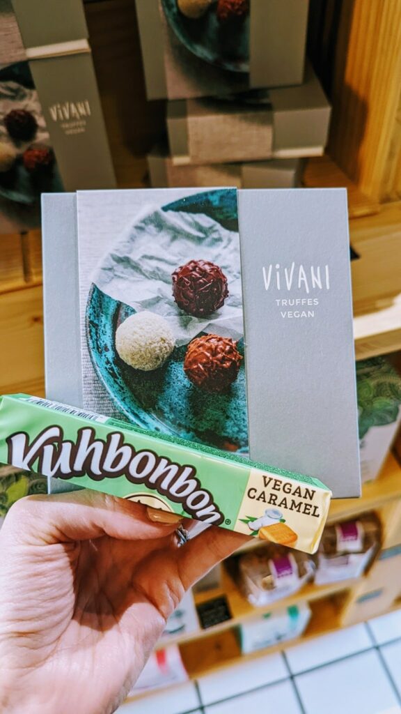 a box of fancy vegan truffles and a package of vegan caramels held together in a store in zurich