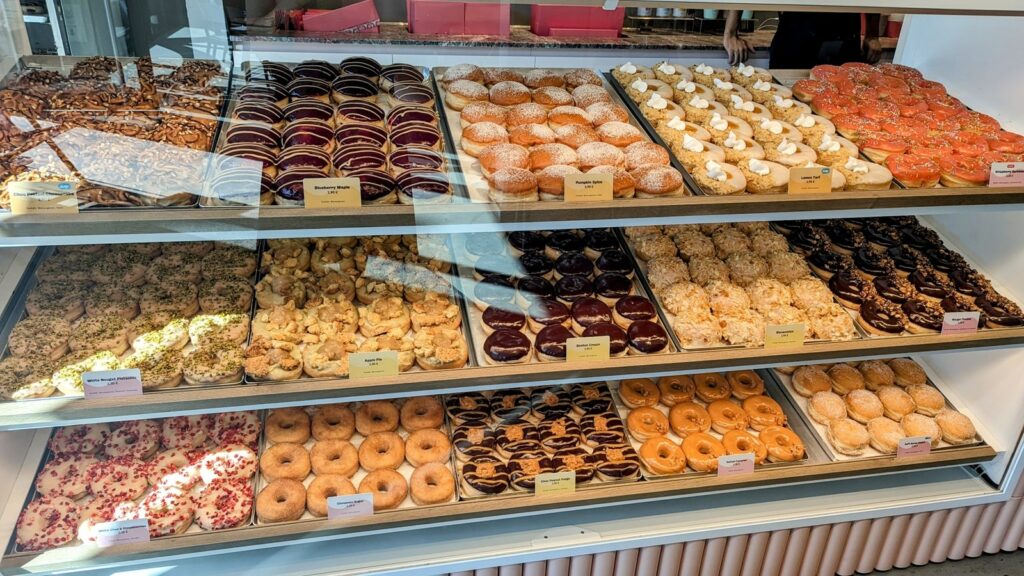 a dessert case filled with colorful vegan donuts all in rows at brammibals in hamburg