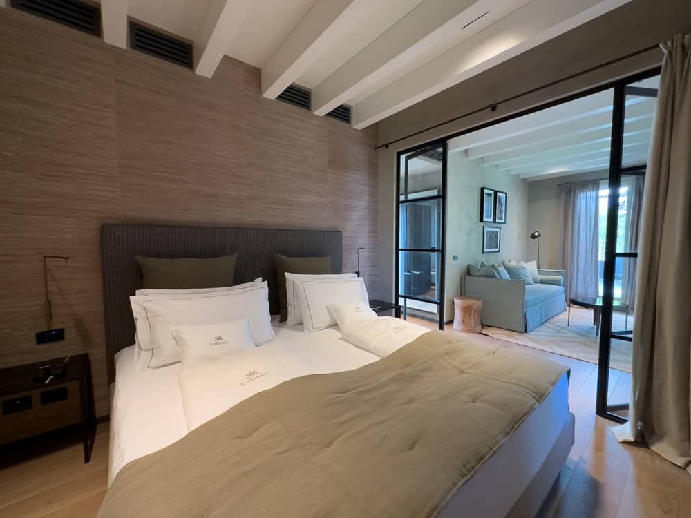 inside of a spacious guestroom with a large king bed and a separate living space at a vegan hotel along lake garda in italy