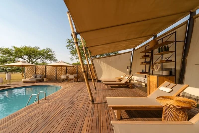 the natural khaki colored tented overhang surronding the small pool area at the Singita Sabora Tented Camp in AFrica